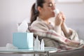 Nasal spray bottles, napkins and blurred view of sick woman on background Royalty Free Stock Photo