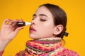 The nasal spray. Female in scarf using nasal spray medicine for runny nose. Nasal spray for allergic rhinitis, cold Royalty Free Stock Photo