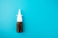 Nasal spray, nose drops in a vial on a blue background, health and medicine, pharmacy and drugs