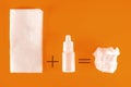 Nasal spray and used paper handkerchiefs on an orange background with a copy of the space. The concept of treating a cold or Royalty Free Stock Photo