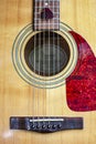 Nashville Acoustic Guitar Sound Hole, strings and Pick with detail of wood grain, pick guard and bridge