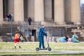 Nashville, Tennessee - March 25, 2019 : A man riding a rented electric scooter around Centennial Park at the Parthenon