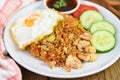 Nasi goreng fried rice chicken with egg tomato cucumber on white plate and sauce - Nasi Goreng Ayam indonesian food Asian Royalty Free Stock Photo