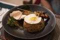 Nasi goreng, a traditional balinese food served during the dinner in a black plate in a restaurant in Bali
