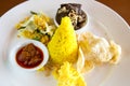 Nasi Kuning Indonesian yellow rice served with braised beef, shredded egg, vegetables, coconut salad, homemade sambal and crackers