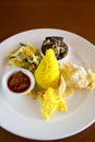 Nasi Kuning Indonesian yellow rice served with braised beef, shredded egg, vegetables, coconut salad, homemade sambal and crackers