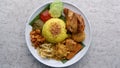 Nasi Kuning or Yellow rice with traditional fried chicken, tofu, tempeh, and smashed potato. Royalty Free Stock Photo