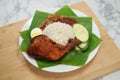 Narrow depth of field Nasi Lemak dish with chicken drum stick on marble surface with coconut leaf