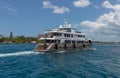 Nassau, Bahamas - May 14, 2019: Luxurious yacht Loon sailing in Nassau harbour. Some crew members on open decks. Turquoise water