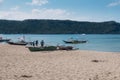 Nasugbu, Batangas, Philippines - Calayo Beach at midday. multiple fishing boats hauled onto the sand. Domestic tourists walk