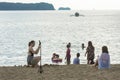 Nasugbu, Batangas, Philippines - Friends take some snap shots while a family take a dip in the sea. A boat loaded with