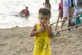 Nasugbu, Batangas, Philippines - A local child nibbles on a piece of watermelon while on the beach