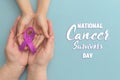 National Cancer Survivors Day. Adult and child hands holding purple ribbon on blue background. Alzheimer`s disease, Pancreatic