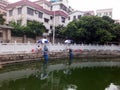 The men are fishing near the pond