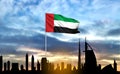 National day of United Arab Emirates. Silhouette of Dubai skyline on background of sunset with UAE flag Royalty Free Stock Photo