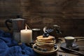 National dish pancakes, pancakes, pita with blueberries, linen napkin, poured with honey, candle burns, a cup of tea, an old mocha