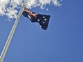National flag of Australia consists of Union Jack and Southern Cross stars constellation in blue sky sunny day with white cloud