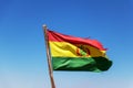 Bolivian Flag waving in the wind against blue sky background Royalty Free Stock Photo