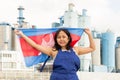 National flag of Cambodia in the hands of girl in overalls against background of modern metallurgical plant