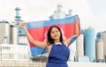 National flag of Cambodia in the hands of girl in overalls against background of modern metallurgical plant