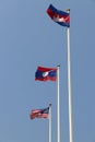 National flag of Cambodia, Laos and Malaysia on bright blue sky background. Blown away by wind. Royalty Free Stock Photo