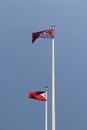 National flag of Cambodia and Philippines on bright blue sky background. Blown away by wind.