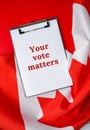The National Flag of Canada. Canadian Flag or the Maple Leaf with paper note message text. Election day, give vote, your