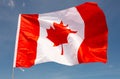 National flag of Canada flies on flagpole against blue sky Royalty Free Stock Photo