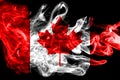 National flag of Canada made from colored smoke isolated on black background. Abstract silky wave background.