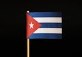 A national flag of Cuba on toothpick and on black background. Cuba is famous for criminality and import and export drugs and cigar