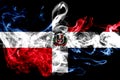National flag of Dominican Republic made from colored smoke isolated on black background. Abstract silky wave background. Royalty Free Stock Photo