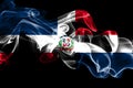 National flag of Dominican Republic made from colored smoke isolated on black background. Abstract silky wave background