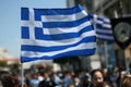 National flag of Greece over a crowded street