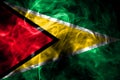 National flag of Guyana made from colored smoke isolated on black background. Abstract silky wave background. Royalty Free Stock Photo