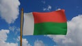 National flag of Madagascar waving 3D Render with flagpole and blue sky, sainani Madagasikara or drapeau de Madagasca Royalty Free Stock Photo