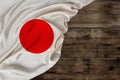 National flag of modern state of Japan, beautiful silk, background old wood, concept of tourism, economy, politics, emigration, Royalty Free Stock Photo