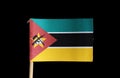 A national flag of Mozambique on toothpick on black background. Consists of horizontal tricolour of green, white edged black and y