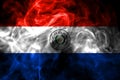 National flag of Paraguay made from colored smoke isolated on black background. Abstract silky wave background.