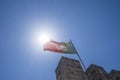 the national flag of portugal flies on top of a battlement of the castle of St. George in Lisbon on a sunny day, blue sky Royalty Free Stock Photo