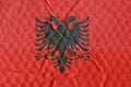 National flag of the Republic of Albania on an uneven textured surface.