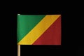 A national flag of the Republic of the Congo on toothpick on black background. Consists of a diagonal tricolour of green, yellow a