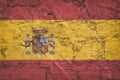 The national flag of Spain on stone wall, grunge background