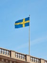 The national flag of Sweden on building against the blue sky. Royalty Free Stock Photo