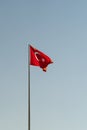 National flag of Turkey featuring white star and crescent waving against blue sky on sunny day Royalty Free Stock Photo