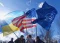 National flag of Ukraine and the United States and flag of NATO are fluttering against the blue sky