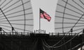 The national flag of United States of America winding on top of Brooklyn Bridge landmark from Manhattan.