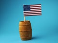 A national flag of USA on wooden stick in wooden barrel on blue background