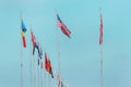 National flags of various countries flying on a blue sky Royalty Free Stock Photo