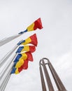 National Heroes Memorial Monument in Carol Park from Bucharest - wide view in a cloudy day with Romanian flags in foreground