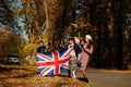 National holiday of United Kingdom. Family with british flags in autumn park. Britishness celebrating UK. Mother with four kids